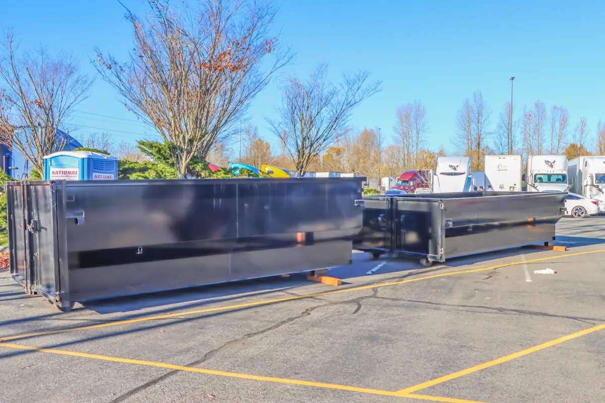 Professional dumpster rental service with roll-off container on residential driveway in Romulus